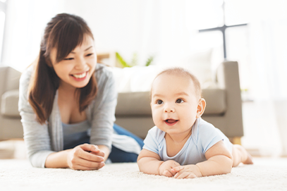 mom on floor with infant doing tummy time