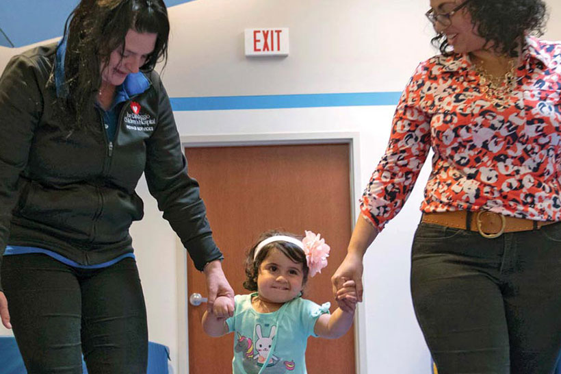 Employee and mother both holding hands with small child