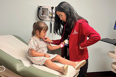 nurse examining child on exam table